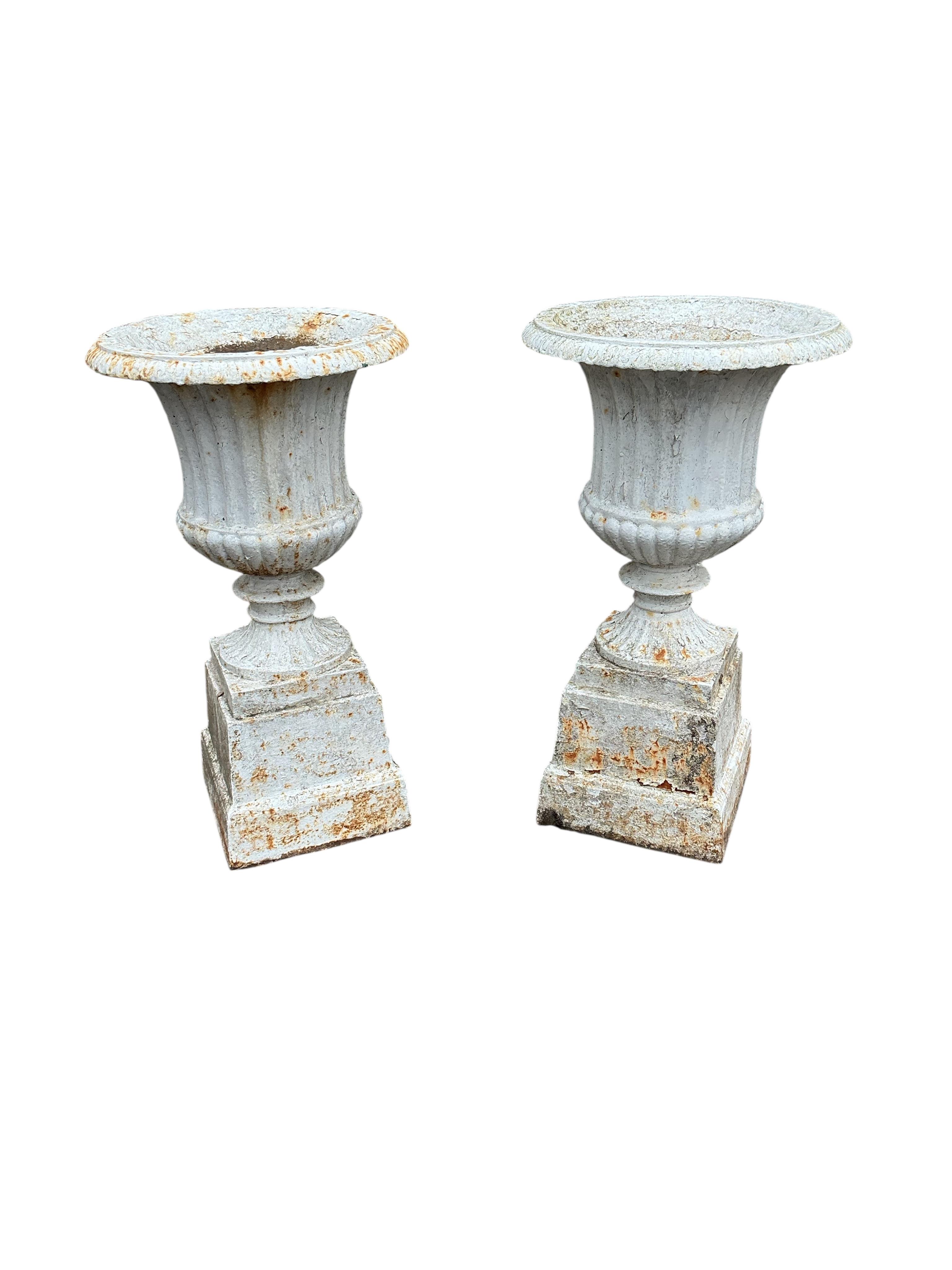 A pair of Victorian cast iron campana garden urns, on square bases, diameter 38cm, height 69cm